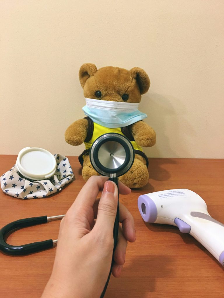 peluche de oso marrón junto a un marco redondo blanco y negro